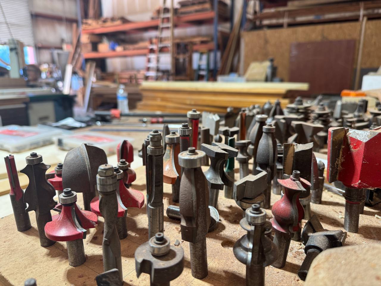 A field of router and profile bits with the shop behind