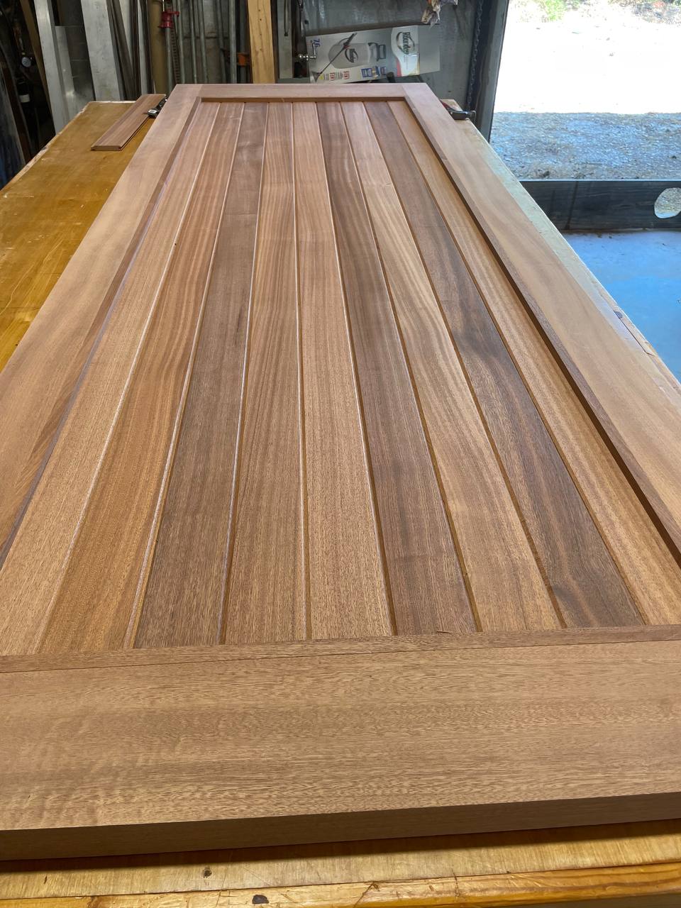 A finished Sapele plank door on the bench