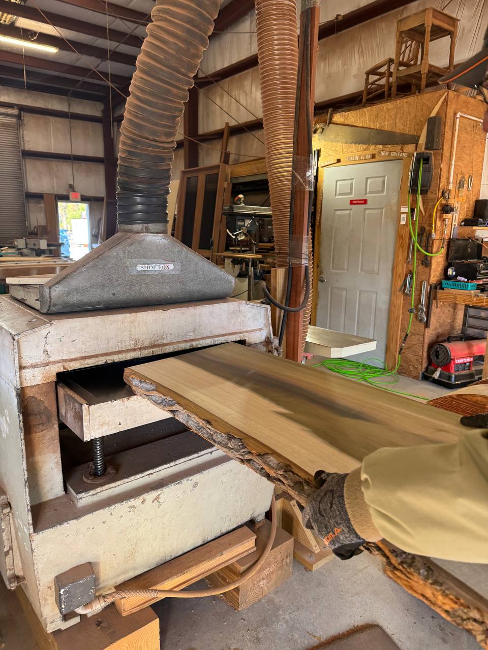 Running a live-edge slab through the planer in the J&P Woodcrafters shop